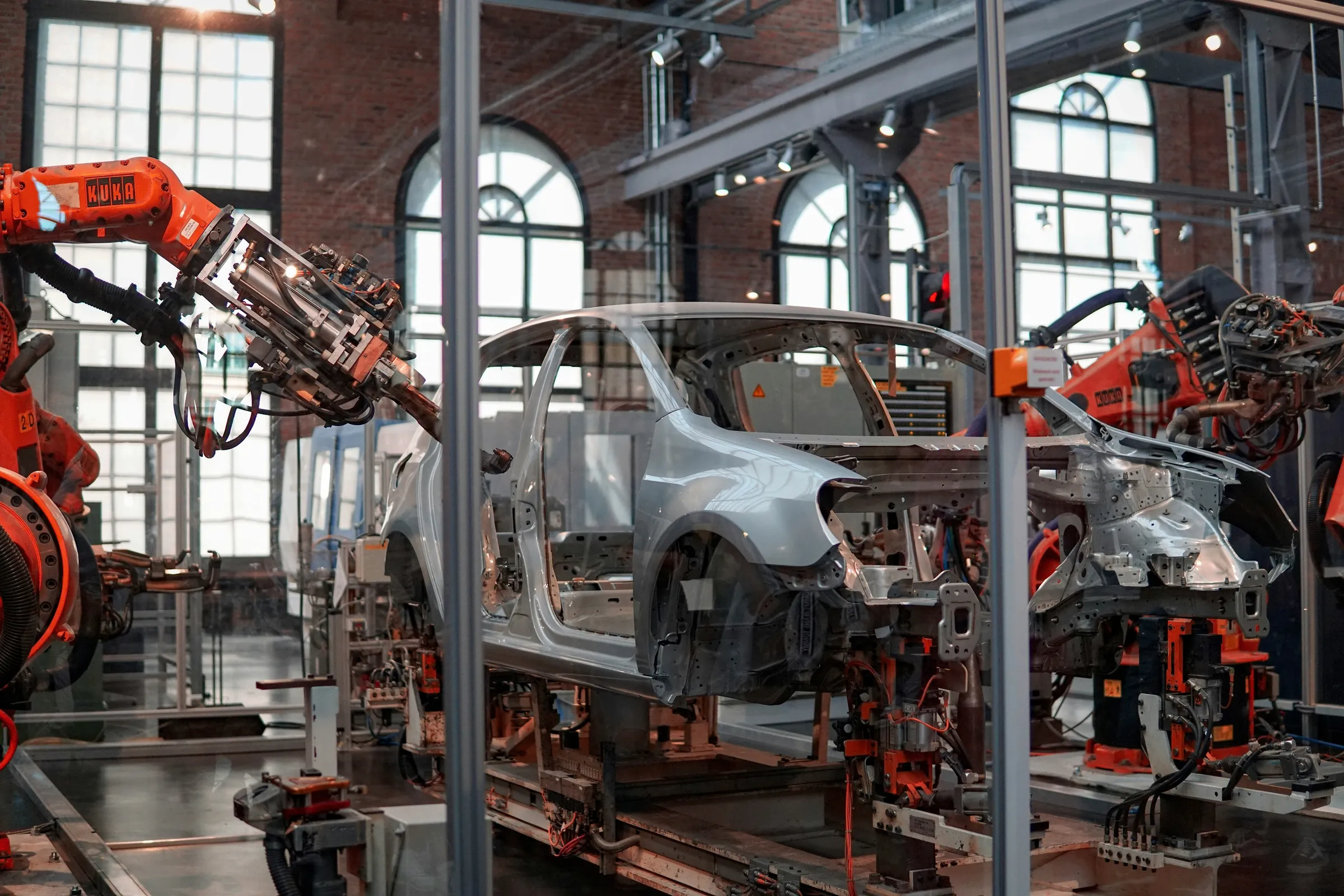 Robot arms working on a car body on an automotive production line