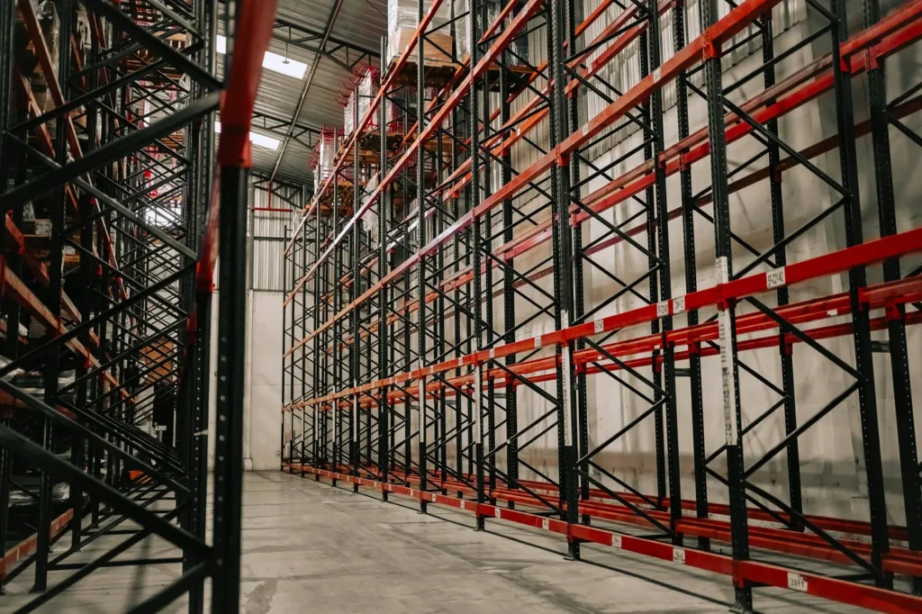 Tall steel pallet racking along an aisle in a distribution warehouse